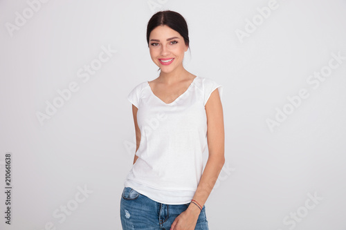 happy brunette woman wearing a white t-shirt standing