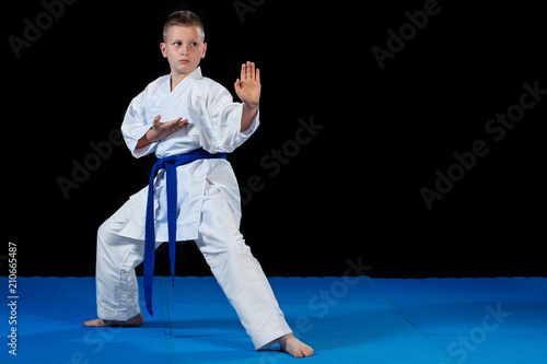 Pre-teen boy doing karate on a black background