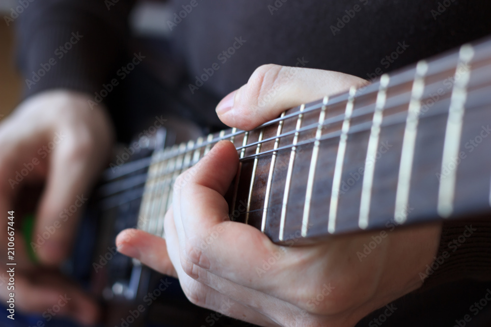 Fototapeta premium Man is playing guitar close up
