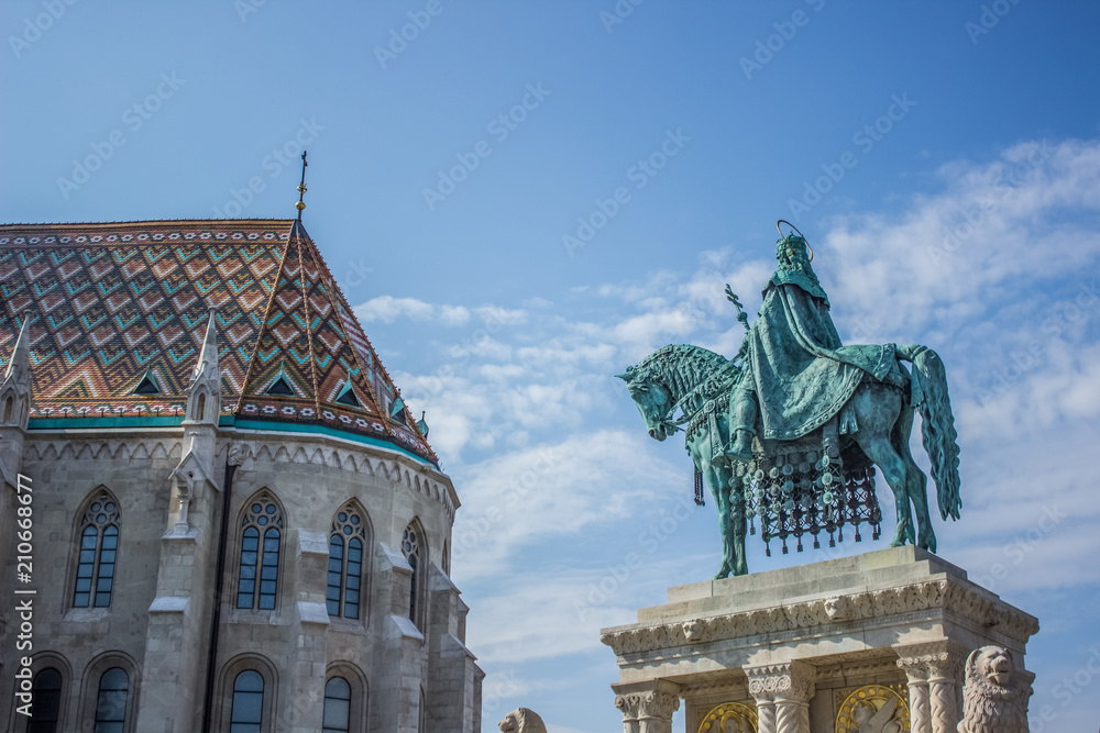 Obraz premium Budapest - capital of Hungary county side monument near catholic church in summer time bright colorful day on blue sky background