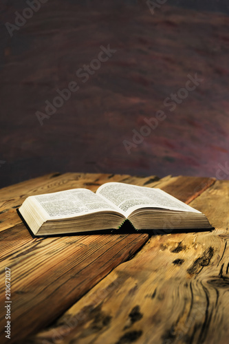 Bible on a old oak wooden table. Beautiful dark background.Religion concept photo