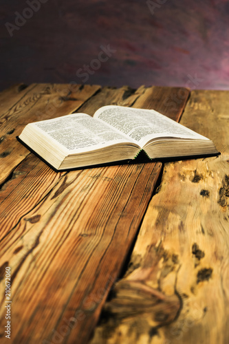 Bible on a old oak wooden table. Beautiful dark background.Religion concept photo