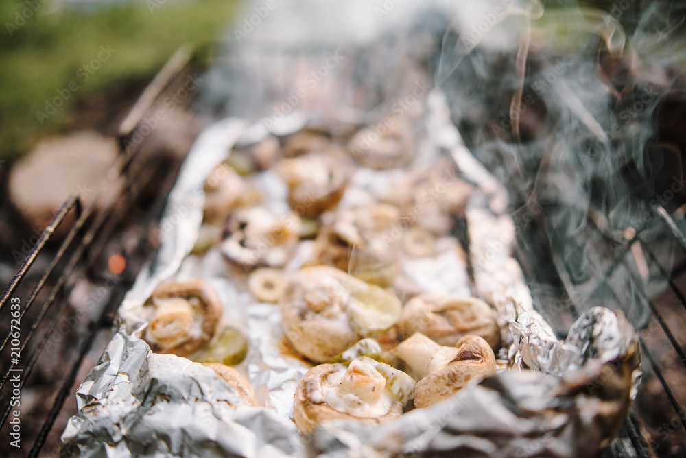 Brown champignon portobello mushrooms being cooked on char grill Brown champignon portobello mushrooms being cooked on char grill