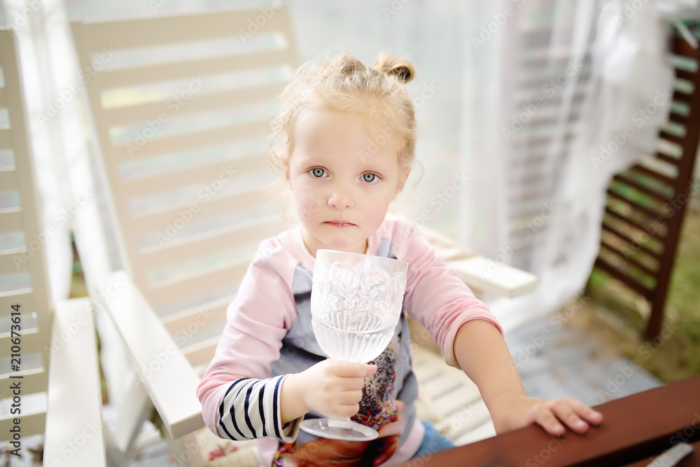 Cute toddler girl drinking still water from a beautiful glass Cute toddler girl drinking still water from a beautiful glass