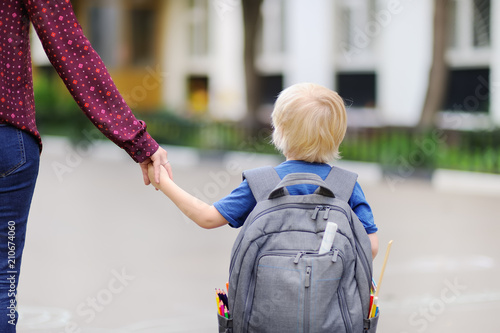 Little pupil with his young mother. First day of primary school. photo