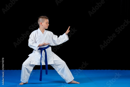 Pre-teen boy doing karate on a black background