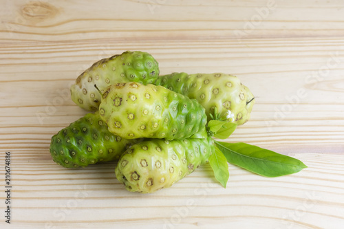 Noni fruit and leaves on wooden table,Top view