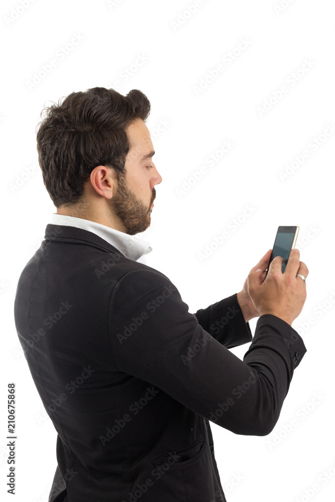 bearded person wears black jacket and white shirt. Isolated. Man on his back is typing on his cell phone.. bearded person wears black jacket and white shirt. Isolated. Man on his back is typing on his cell phone..
