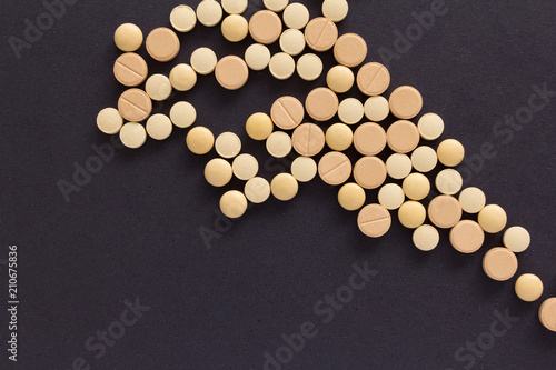 Group of assorted beige tablets. Black background. Line, way course concept.