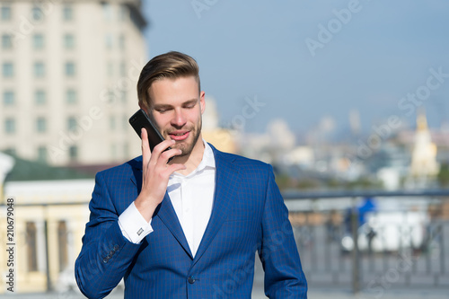 Happy man with mobile phone on sunny terrace. Businessman use smartphone with smile. Great business news. Business communication. Communication and agile business. New technology and modern life