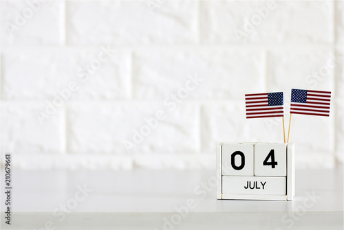 4th of July calendar and American Flag on the table White brick wall background Concept Happy Independence Day