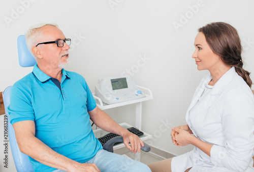 Female doctor in discussion with mature male patient at medical clinic
