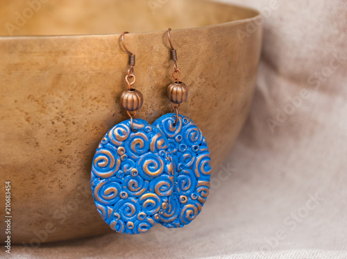 Blue and gold helix earrings. Handmade jewelry from polymer clay. Fashion background with accessories.