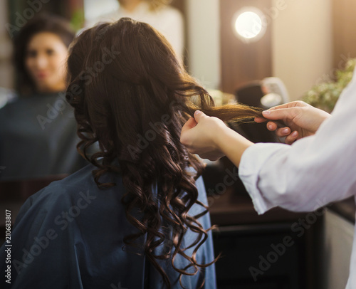 Hairdresser making curly hair to client