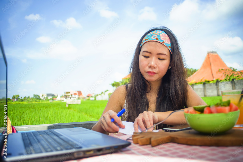 young attractive and happy Asian Korean digital nomad working outdoors relaxed with laptop computer writing notes in success job as online social media travel blogger young attractive and happy Asian Korean digital nomad working outdoors relaxed with laptop computer writing notes in success job as online social media travel blogger