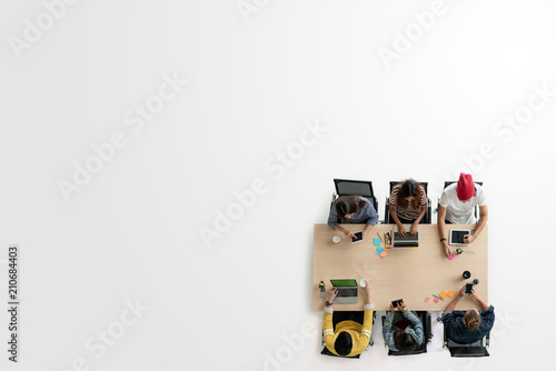 Top view of diverse people of creative team group using smartphone, tablet and computer laptop. Overhead of asian young creative start up meeting. Have copy space for fill text