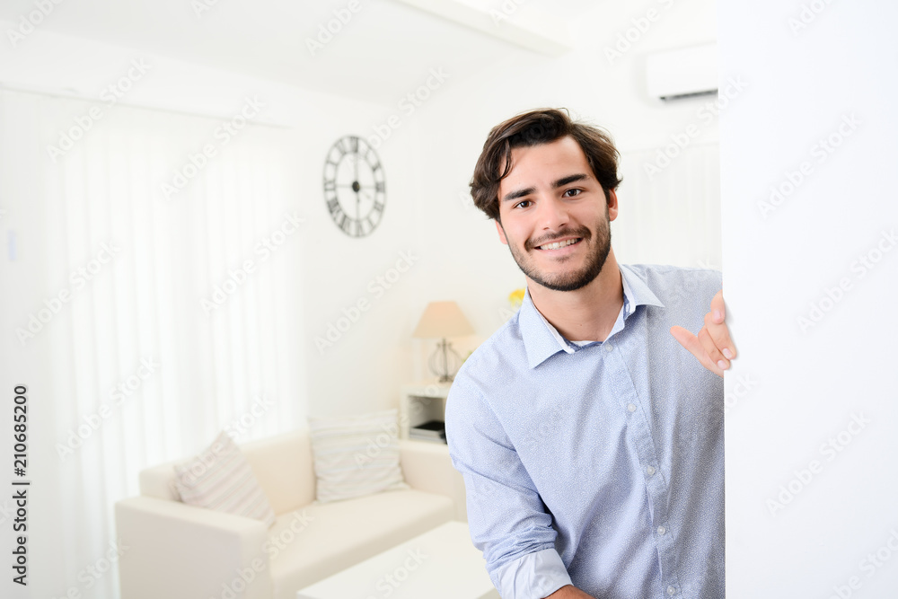 handsome young man welcome friends at open front door new student home apartment
