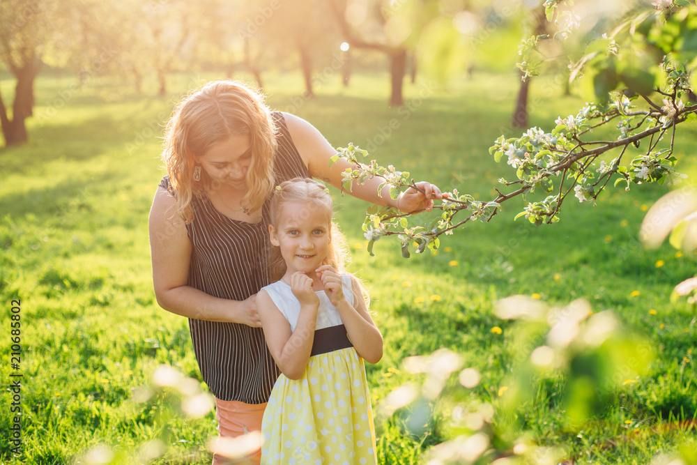 Mother and daughter having fun in the park. Happiness and harmony in family life. Beauty nature scene with family outdoor lifestyle. Mother and daughter having fun in the park. Happiness and harmony in family life. Beauty nature scene with family outdoor lifestyle.