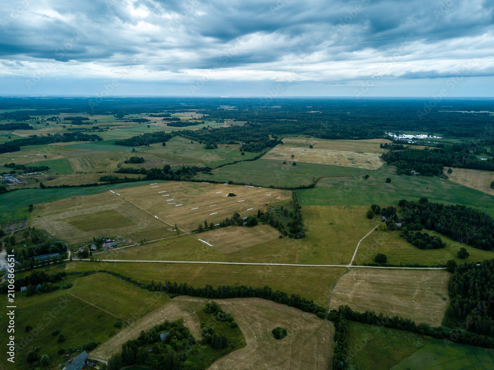 drone image. aerial view of rural area with houses and roads under heavy rain clouds