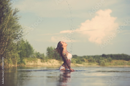 Fototapeta Naklejka Na Ścianę i Meble -  Tattooed Woman Splashing Water