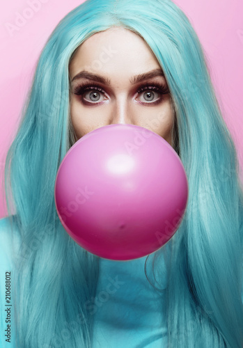 Beautiful young woman face close up, blowing a balloon  © Tijana