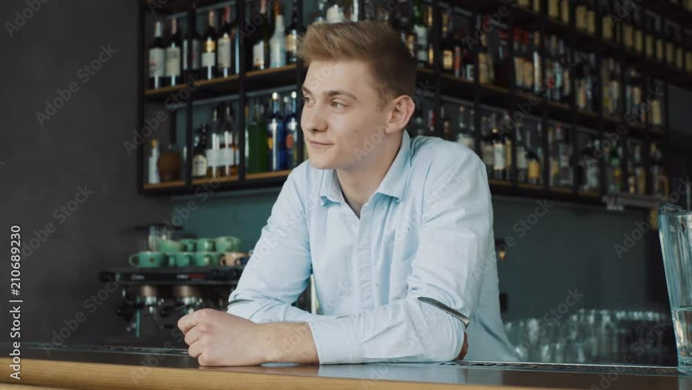 Portrait of a happy young bartender behind the counter Portrait of a happy young bartender behind the counter