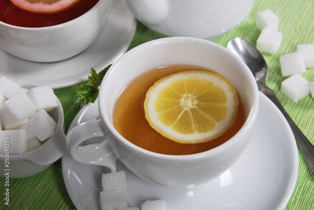 herba with lemon in a white cup with sugar cubes herba with lemon in a white cup with sugar cubes