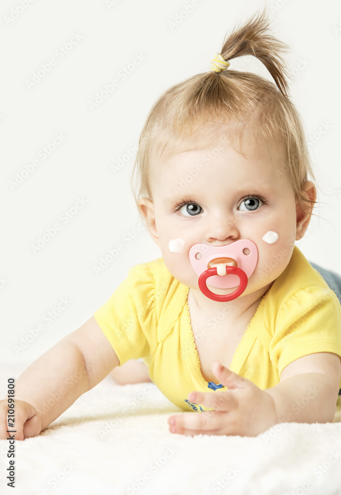 Studio portrait of adorable baby girl with cream on her cheeks Studio portrait of adorable baby girl with cream on her cheeks
