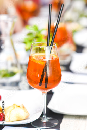 A orange drink in a glass of wine in the restaurant beautifully served.