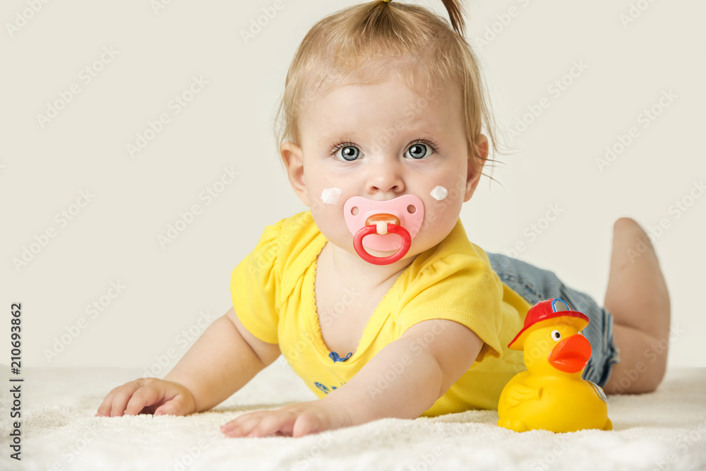 Studio portrait of adorable baby girl with cream on her cheeks
