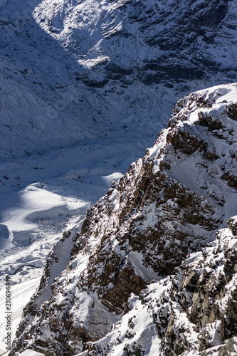 Schnee-Berge mit Felsen