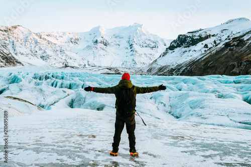 Obraz na płótnie adventurous man walking on a glacier in iceland w salonie