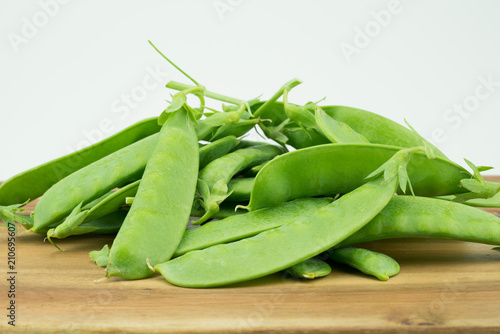 Fresh harvested Snow pea (Pisum sativum var. saccharatum) also known as mangetout organical grown in my garden isolated on wooden background photo