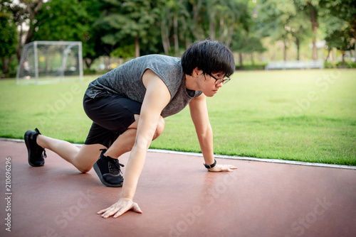 Male sprinter starting on the running track