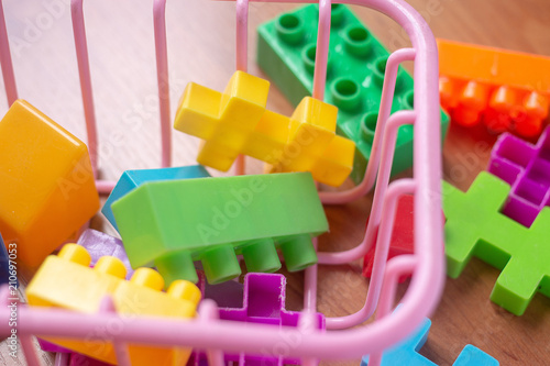 Toy colorful plastic blocks on wooden floor background