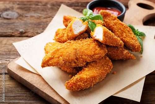 Fotografia Delicious crispy fried breaded chicken breast strips with ketchup