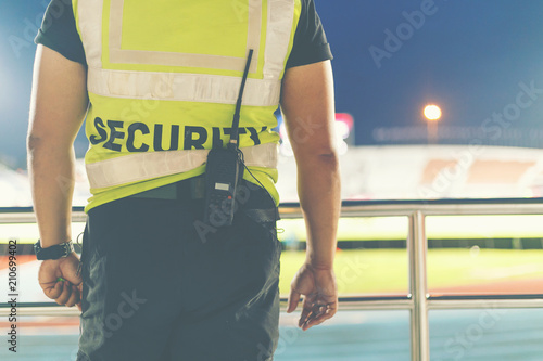 Back of security standing in the soccer stadium.