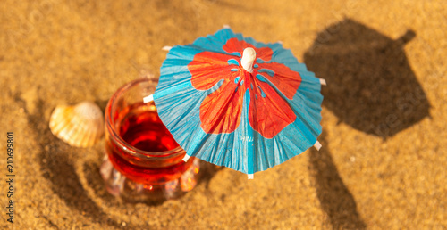 colorful shots drinks on a sandy beach with umbrellas for drinks