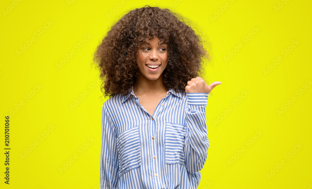 African american woman wearing a stripes shirt pointing with hand and finger up with happy face smiling African american woman wearing a stripes shirt pointing with hand and finger up with happy face smiling