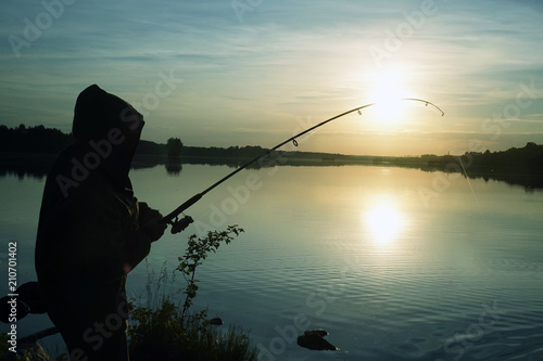 Fisherman silhouette at sunset. hobby, sport. © andreysha74