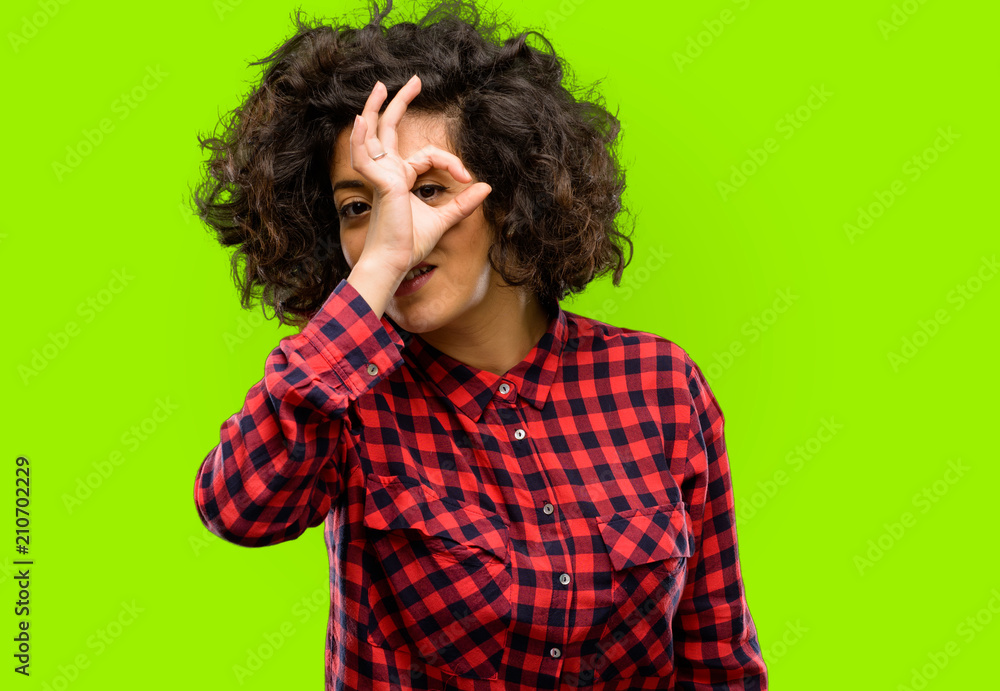 Beautiful arab woman looking at camera through fingers in ok gesture. Imitating binoculars, beautiful eyes and smile Beautiful arab woman looking at camera through fingers in ok gesture. Imitating binoculars, beautiful eyes and smile