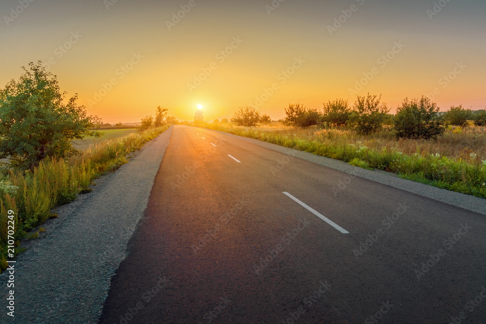 Beautiful rural asphalt road sunset landscape.
