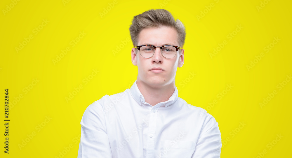 Young handsome blond man skeptic and nervous, disapproving expression on face with crossed arms. Negative person. Young handsome blond man skeptic and nervous, disapproving expression on face with crossed arms. Negative person.