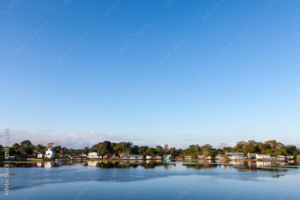 Amazonas, Brazil. View of a small village on the Negro River in the Amazon with blue sky.