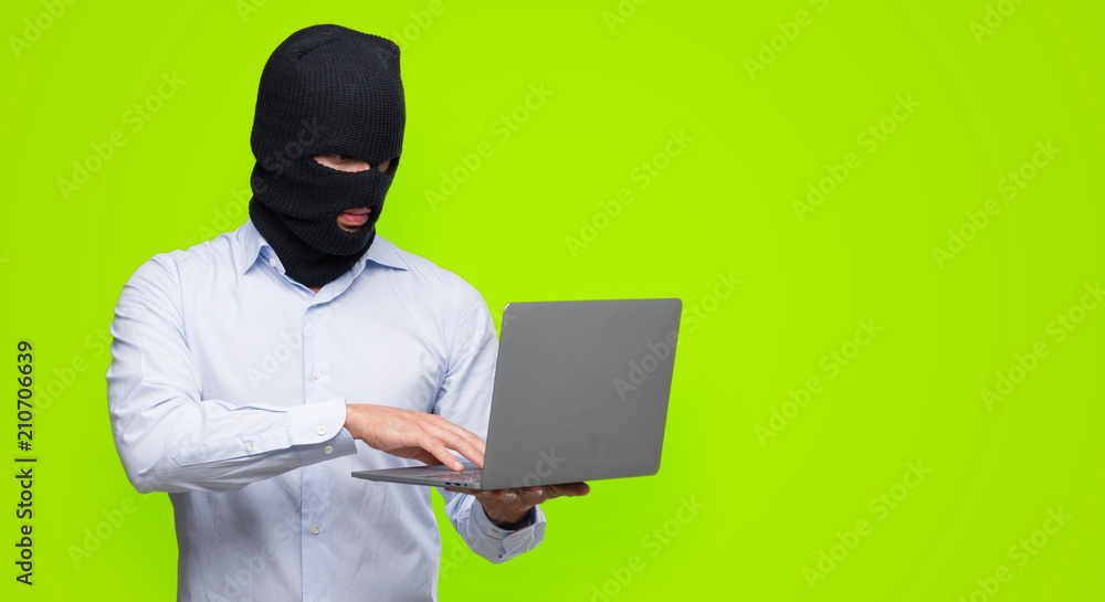 Business hacker man holding a computer laptop with a confident expression on smart face thinking serious Business hacker man holding a computer laptop with a confident expression on smart face thinking serious