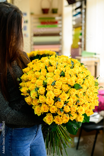 Fototapeta Naklejka Na Ścianę i Meble -  Happy brunette girl received big bouquet of beautiful fresh yell