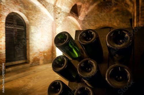 Pupitre and bottles inside an underground cellar for the production of traditional method sparkling wines in italy photo