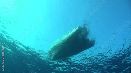 dive boat floating at sunlight - view from underwater