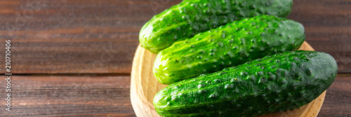 Fresh raw green cucumbers on a wooden table banner