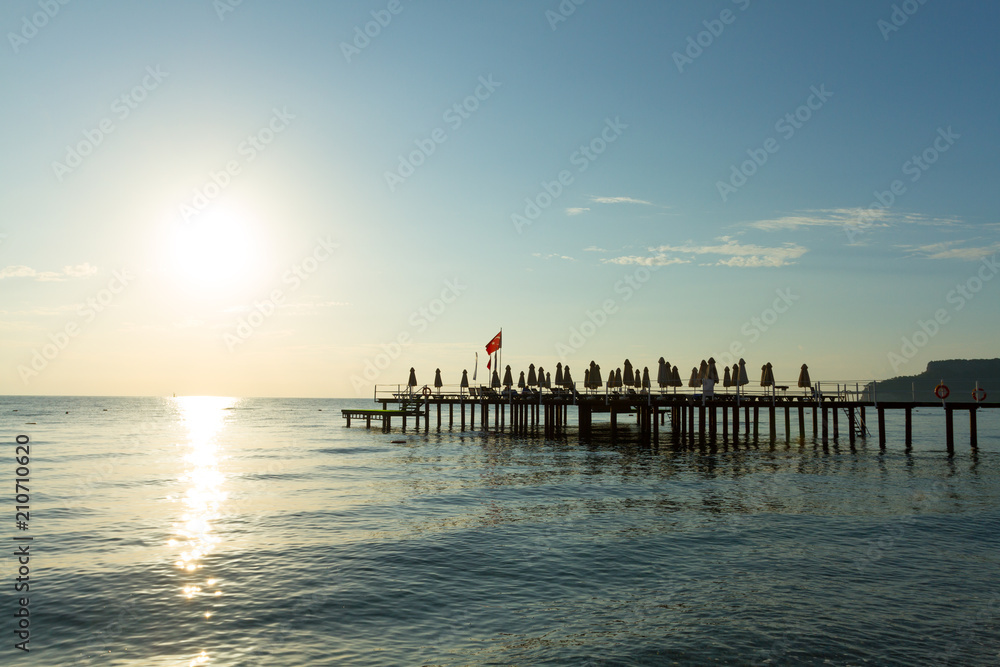 Pier with flag at sunrise in Kemer Pier with flag at sunrise in Kemer